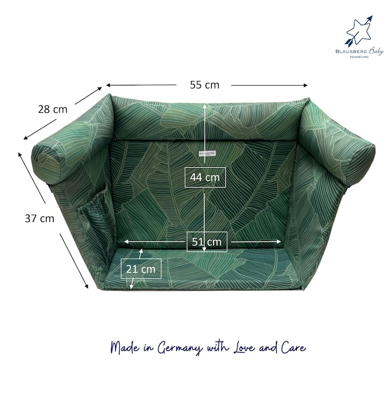 Grünes Babybett mit tropischem Blättermuster. Das Bett ist 55 cm lang, 28 cm breit und 37 cm hoch. Die Innenmaße betragen 51 cm Länge und 44 cm Breite. Der Text "Made in Germany with Love and Care" ist sichtbar.