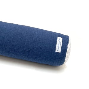 Op de afbeelding: Een blauw cilindrisch kussen met een wit label waarop "Blausberg Baby Hamburg" staat.