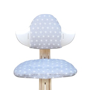 May include: A white and gray ergonomic chair with a geometric patterned cushion. The chair has a unique design with a curved backrest and a rounded seat.
