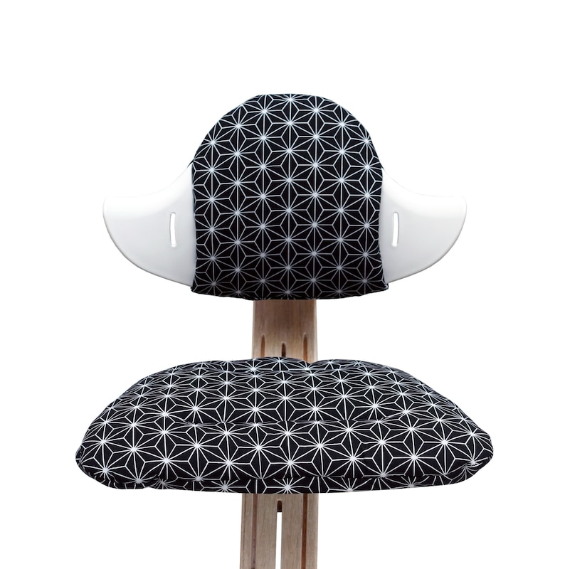 May include: A black and white geometric patterned chair with a white back and a separate cushion. The chair is made of wood and has a modern design.