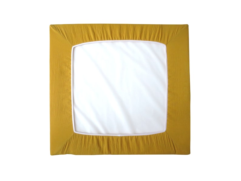 May include: A mustard yellow fitted sheet with a white border. The sheet is made of a soft, textured fabric.