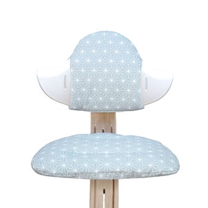 May include: A white chair with a light blue geometric patterned cushion on the seat and back.