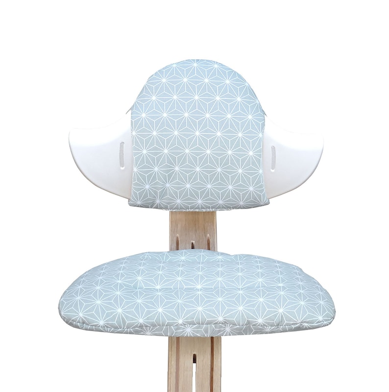 May include: A white chair with a light blue geometric patterned cushion on the seat and back.