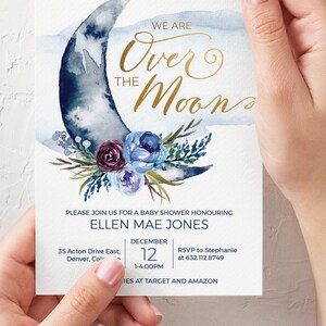 Peut inclure: Une invitation &agrave; une f&ecirc;te pr&eacute;natale avec un croissant de lune aquarelle bleu et blanc avec une inscription dor&eacute;e qui dit "We are Over the Moon". L'invitation est d&eacute;cor&eacute;e de fleurs bleues et violettes. Le texte sur l'invitation se lit comme suit : "Veuillez vous joindre &agrave; nous pour une f&ecirc;te pr&eacute;natale en l'honneur d'Ellen Mae Jones, le 12 d&eacute;cembre, de 13h00 &agrave; 16h00, 35 Acton Drive East, Denver, CO, RSVP &agrave; Stephanie au 632.112.8749, Cadeaux chez Target et Amazon."