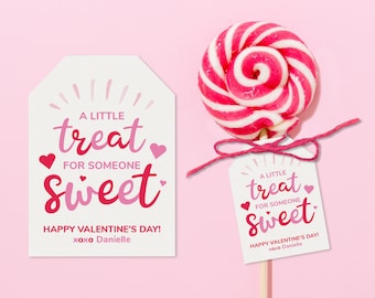 May include: A white tag with pink and red text that reads "A little treat for someone sweet. Happy Valentine's Day! xoxo Danielle". The tag is tied to a pink and white swirl lollipop.