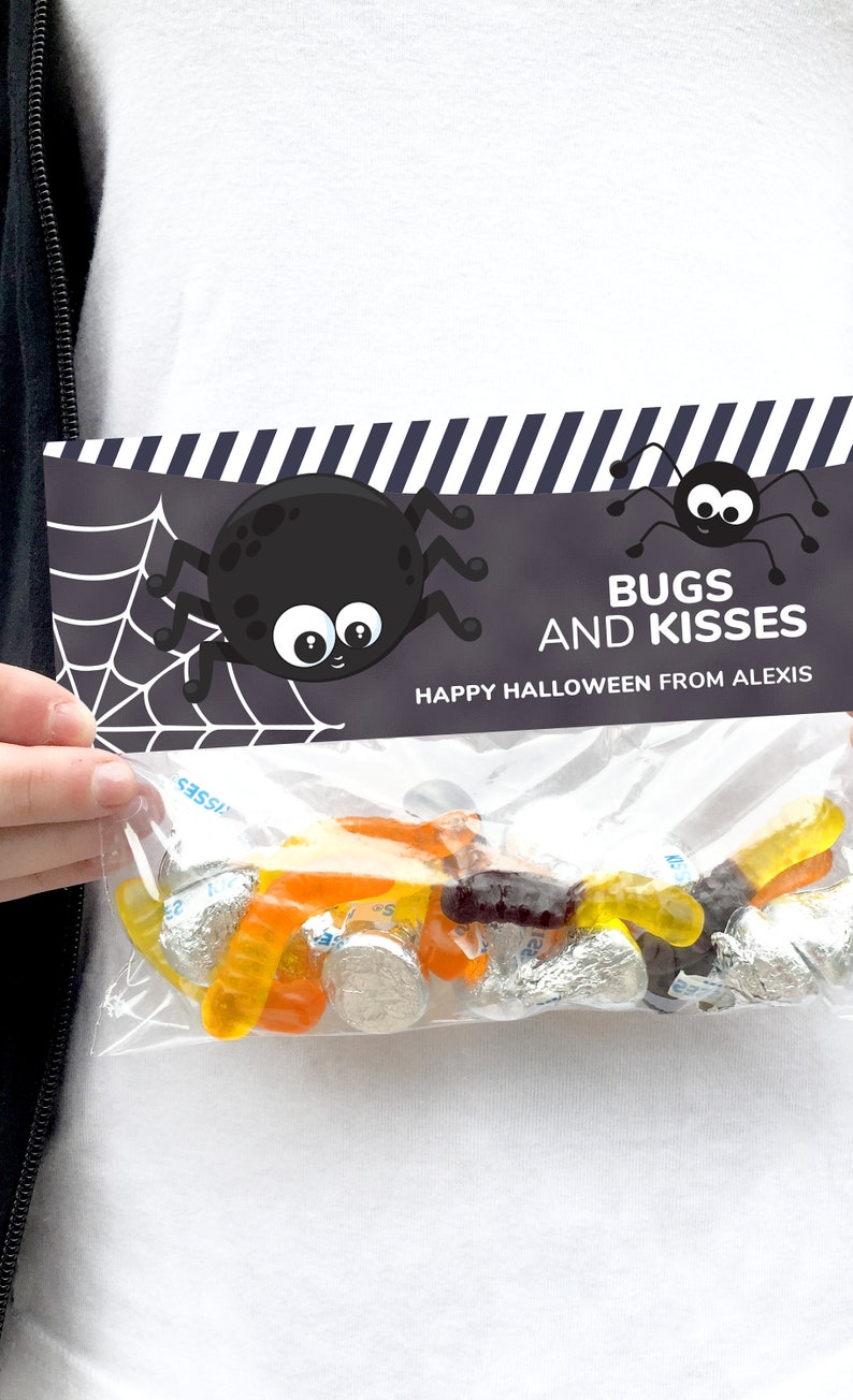 May include: A clear plastic treat bag filled with orange and yellow gummy worms and silver-wrapped chocolate candies. The bag is sealed with a black and white striped cardstock topper featuring two cartoon spiders and the text BUGS AND KISSES.