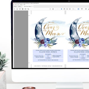 Peut inclure: Un &eacute;cran num&eacute;rique affichant une invitation &agrave; une f&ecirc;te pr&eacute;natale avec un motif de lune bleue et dor&eacute;e et de fleurs. Le texte de l'invitation indique "We are over the moon" et comprend le nom de la personne &agrave; qui l'on souhaite une f&ecirc;te pr&eacute;natale, la date, l'heure et les informations RSVP. L'invitation est modifiable dans Adobe Acrobat Reader.