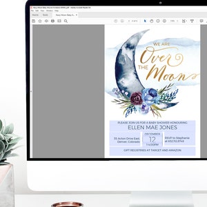 Peut inclure: Une illustration aquarelle bleue et blanche d'un croissant de lune avec une inscription dor&eacute;e qui dit "We are Over the Moon". L'illustration est entour&eacute;e d'un arrangement floral de fleurs bleues et violettes. Le texte sous l'illustration dit "Please join us for a baby shower honouring Ellen Mae Jones, December 12, 1-4:00PM, 35 Acton Drive East, Denver, Colorado, RSVP to Stephanie at 632.112.8749, Gift registries at Target and Amazon".