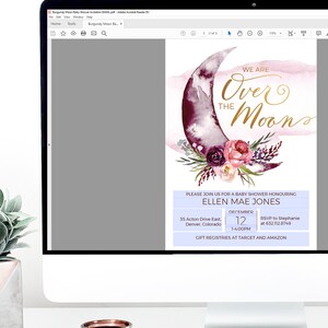K&ouml;nnte beinhalten: Ein digitales Bild einer Babyparty-Einladung mit einer Aquarell-Illustration eines Halbmondes mit rosa und violetten Blumen. Der Text lautet "We are over the moon" in goldener Schrift. Die Einladung enth&auml;lt den Namen des Babys, das Datum, die Uhrzeit und den Ort der Party. Der Text enth&auml;lt auch den Satz "Gift registries at Target and Amazon".