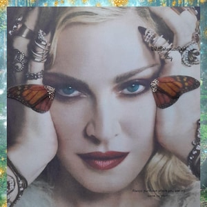 May include: A portrait of a person with blonde hair, blue eyes, and red lipstick, wearing multiple silver rings on their fingers. Two orange and black butterfly wings are positioned near the eyes. The text WildBohemianRose etsy is visible.