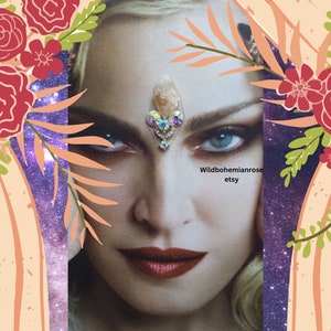 May include: A portrait of a woman with blue eyes and red lipstick, adorned with a crystal and jewel headpiece. The image is framed with floral and leaf accents, and the background features a starry galaxy design. The Etsy shop name "Wildbohemianrose" is visible.