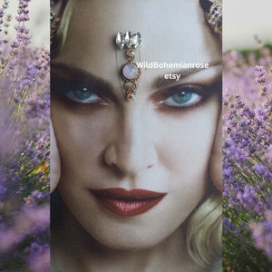 May include: A delicate forehead chain with a pink stone and clear rhinestones. The chain is made of gold-toned metal and has a delicate, feminine design. WildBohemianrose etsy.