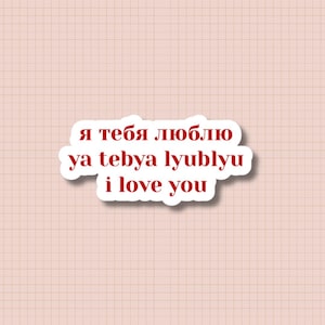 May include: A white sticker with the text "я тебя люблю ya tebya lyublyu i love you" in red and black font. The sticker is on a pink background with a grid pattern.