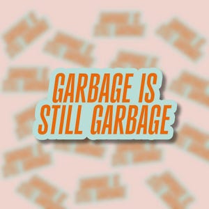 May include: A sticker with the text "GARBAGE IS STILL GARBAGE" in orange, outlined in white, on a light blue background. The sticker is surrounded by blurred, orange text stickers on a pink background.