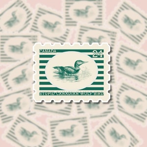 May include: A sticker featuring a vintage-style postage stamp design. The stamp has a green border and the word "CANADA" at the top. The stamp features an illustration of a bird in water, with the text "STUPID CANADIAN WOLF BIRD" at the bottom.