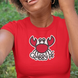 red t-shirt with a minimalist graphic crab illustration with hand lettering Crabby AF