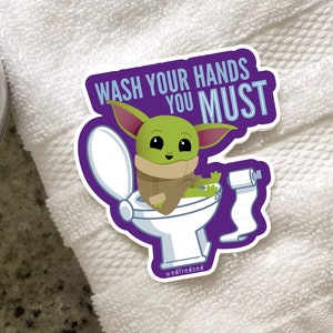 Vibrant Baby Yoda vinyl sticker. Baby Yoda is sitting on the toilet saying Wash Your Hands You Must