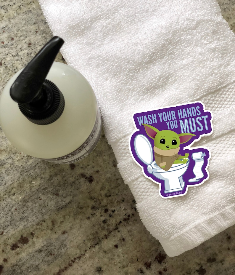 Vibrant Baby Yoda vinyl sticker. Baby Yoda is sitting on the toilet saying Wash Your Hands You Must