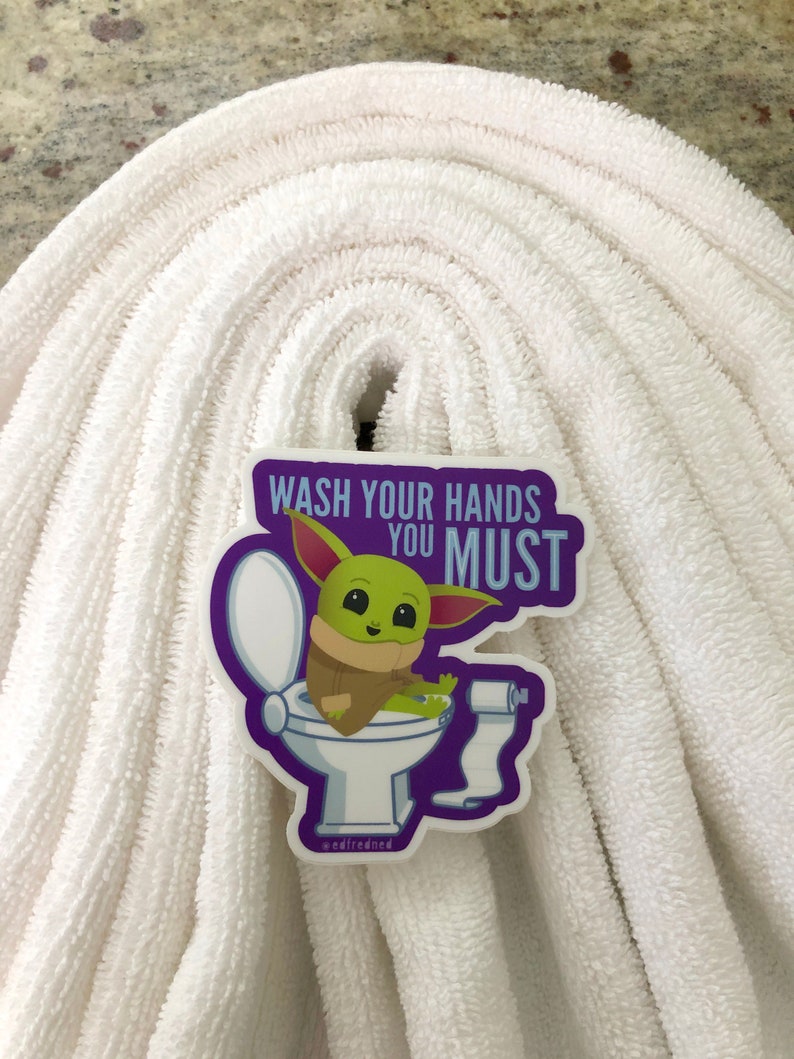 Vibrant Baby Yoda vinyl sticker. Baby Yoda is sitting on the toilet saying Wash Your Hands You Must