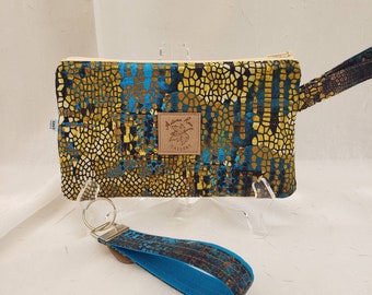 Wristlet/key fob set, Gilded Mosaic in gold-tones with turquoise accents and lining. Wristlet measures 8.5+"x 5", 2 inside pockets