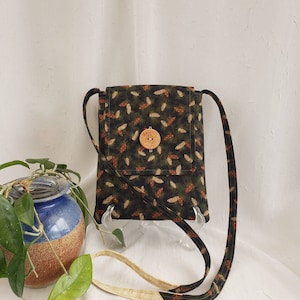 Crossbody bag, Pinecones of rust & beige on dark green, beige lining, 2 inside pockets, button closure, 51&quot; strap