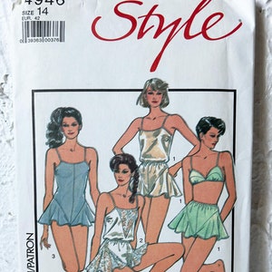 Peut inclure: Un patron de couture pour trois styles différents de lingerie. Le patron est pour la taille 14 (taille européenne 42). Le patron comprend une robe de nuit blanche avec des bordures en dentelle, une robe de nuit en satin vert avec un ourlet à volants et une robe de nuit en satin bleu avec un ourlet à volants.