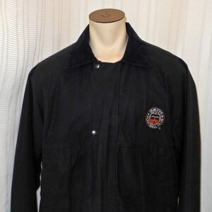 May include: Black jacket with a corduroy collar and a patch on the chest that says "Bath Football Club".