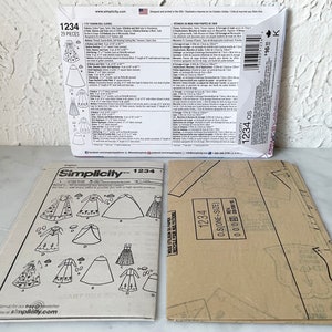 May include: A Simplicity sewing pattern for a doll dress. The pattern is numbered 1234 and includes 29 pieces. The pattern includes instructions for making a variety of doll dresses, including a long-sleeved dress, a short-sleeved dress, and a sleeveless dress.