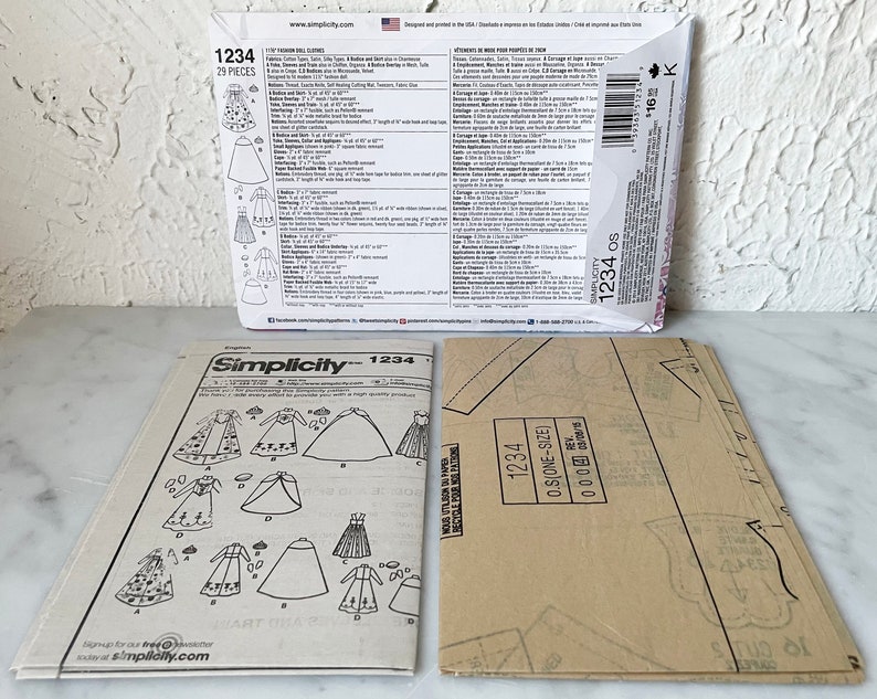 May include: A Simplicity sewing pattern for a doll dress. The pattern is numbered 1234 and includes 29 pieces. The pattern includes instructions for making a variety of doll dresses, including a long-sleeved dress, a short-sleeved dress, and a sleeveless dress.