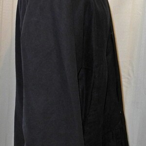 May include: A black corduroy jacket with a velvet collar. The jacket has a long sleeve and a button closure.