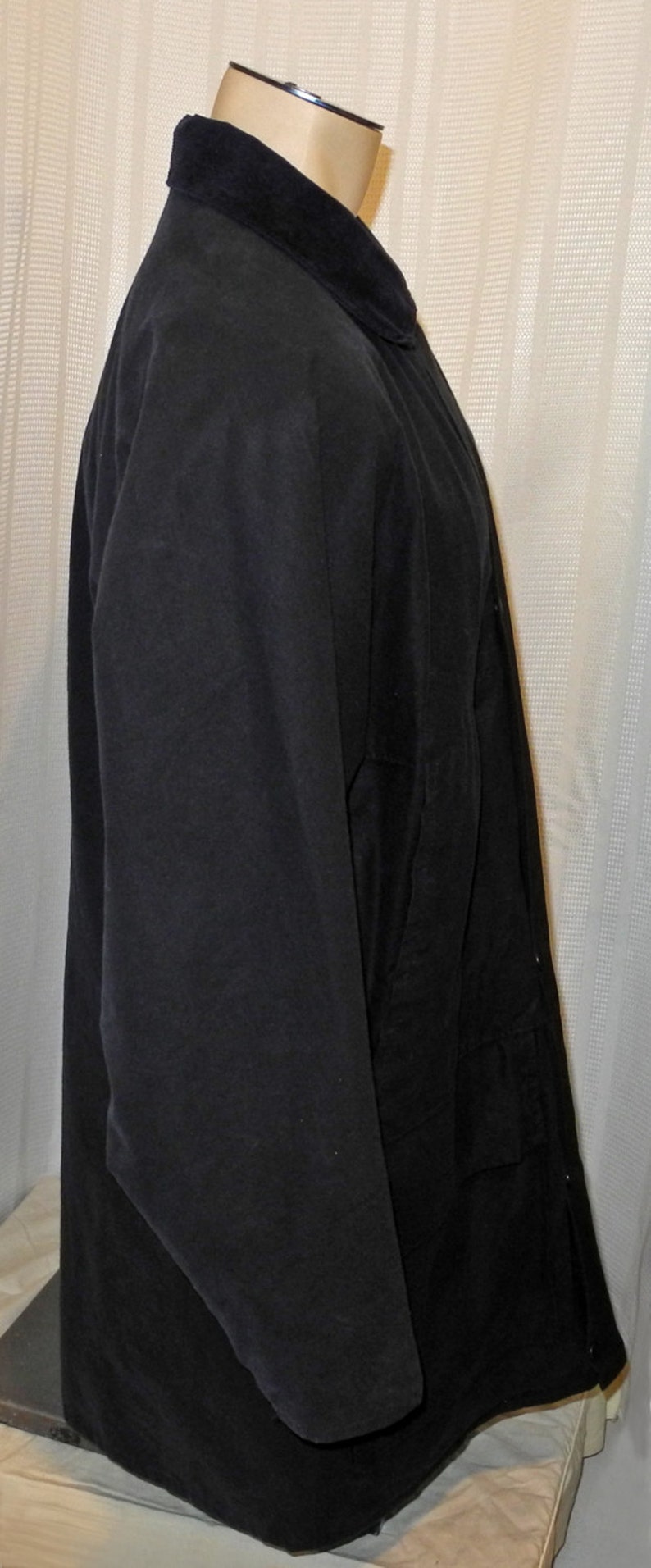 May include: A black corduroy jacket with a velvet collar. The jacket has a long sleeve and a button closure.