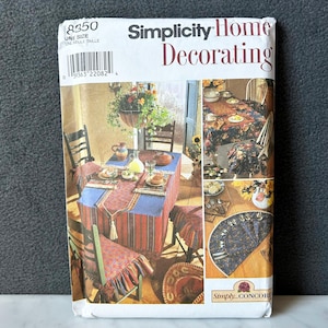 Op de afbeelding: Een Simplicity Home Decorating patroonpakket met afbeeldingen van tafelopstellingen met bloemrijke tafelkleden, placemats en stoelhoezen. Het pakket bevat het nummer 8350 en de tekst "ONE SIZE".