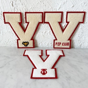 May include: Three varsity letter V patches with red felt borders. Two large cream-colored patches feature a gold lamp icon and the text PEP CLUB in red. One smaller white patch features a red lyre icon at the base of the letter V.