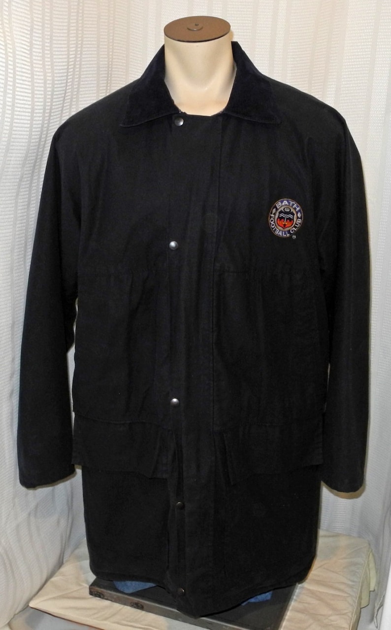 May include: Black jacket with a corduroy collar and a patch on the chest that says "Bath Football Club".