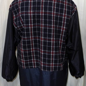 May include: A navy blue jacket with a plaid fleece lining and a black patch on the back that says "Monsoon Country Covers".
