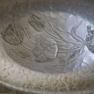 Peut inclure: Un bol de service en m&eacute;tal argent&eacute; avec un motif en relief de tulipes. Le bol a une texture martel&eacute;e.