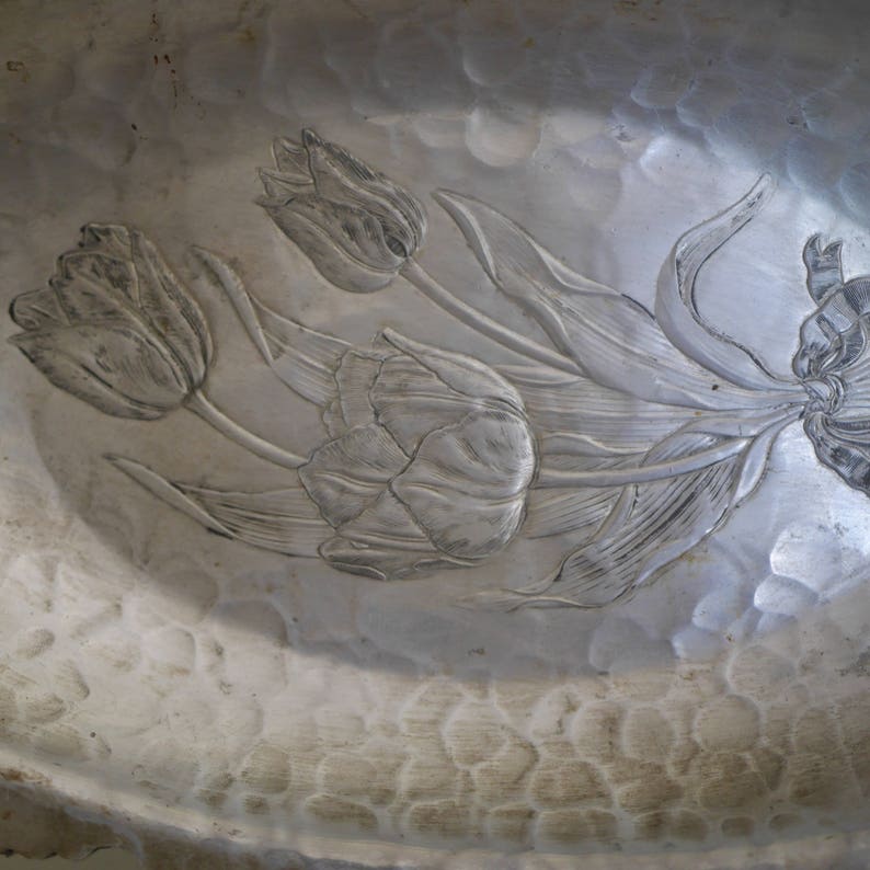 Peut inclure: Un bol de service en m&eacute;tal argent&eacute; avec un motif en relief de tulipes. Le bol a une texture martel&eacute;e.