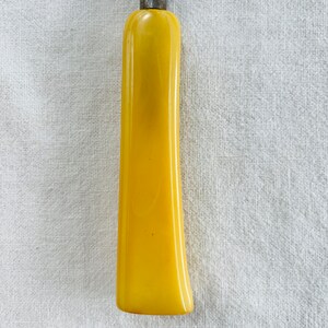May include: A yellow plastic handle for a screwdriver or other tool.
