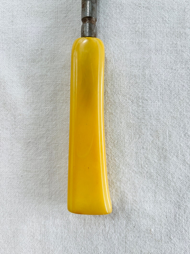 May include: A yellow plastic handle for a screwdriver or other tool.