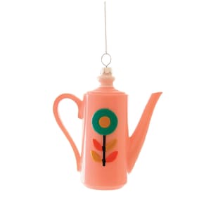May include: A pink teapot-shaped Christmas ornament with a green and yellow flower design. The ornament has a handle and a spout, and is suspended by a silver chain. The ornament is made of glass.