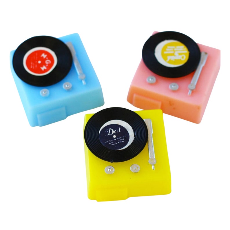 May include: Three miniature toy record players, one blue, one pink, and one yellow, each with a black vinyl record and a silver tone arm.