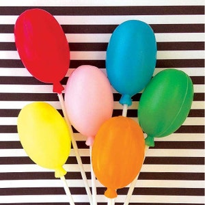 May include: Six colorful balloon shaped party decorations on white sticks against a black and white striped background. The balloons are red, blue, pink, green, yellow, and orange.