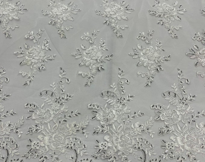 White flower lace corded and embroider silver sequins on a mesh-Sold by the yard.