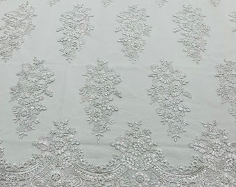 White corded embroider with clear sequins on a mesh lace fabric-prom-sold by the yard.