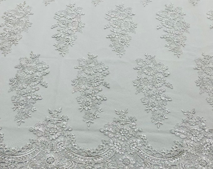 White corded embroider with clear sequins on a mesh lace fabric-prom-sold by the yard.