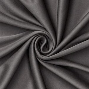 Könnte beinhalten: Ein einfarbiger, dunkelgrauer Stoff mit glatter, matter Textur, der in einem zentralen Spiralmuster angeordnet ist und tiefe, fließende Falten sowie Schatten erzeugt, die von der Mitte ausstrahlen und die gleichmäßige Farbe betonen.