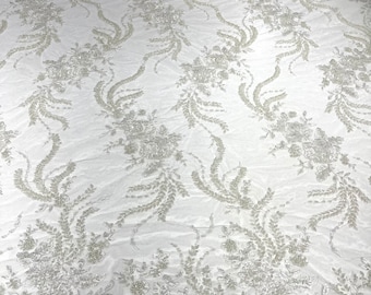 Ivory flowers embroider and heavy beaded on a mesh lace fabric-sold by the yard.