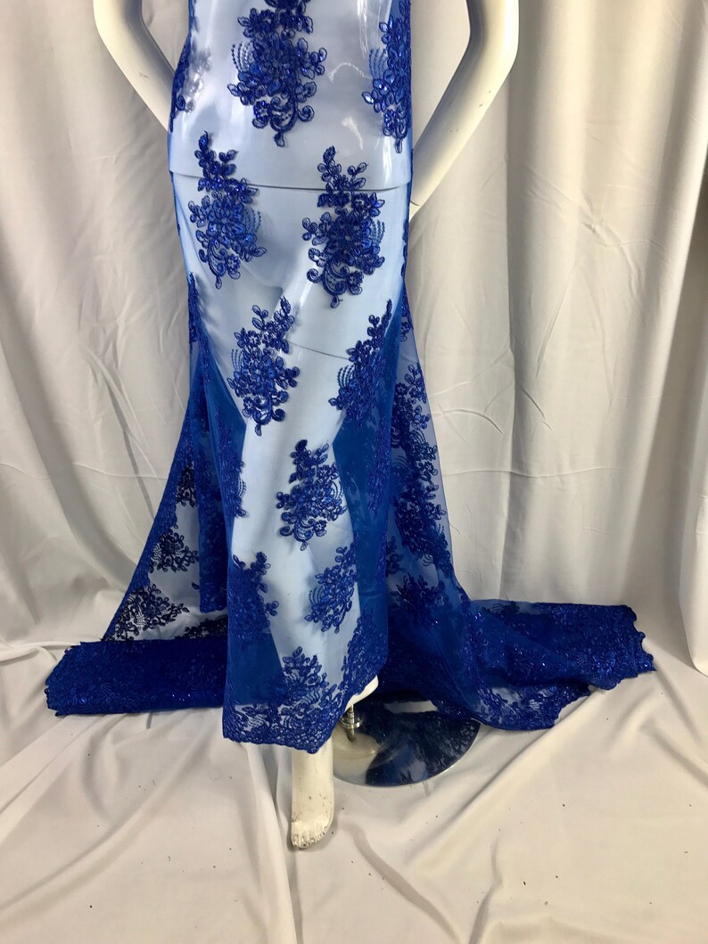 Puede incluir: Tela de encaje azul real con un patr&oacute;n floral. El encaje es transparente y tiene una textura delicada.