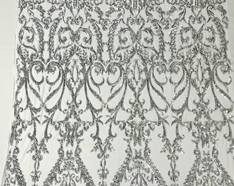 Silver shiny sequin damask design on a white 4 way stretch mesh-sold by the yard.