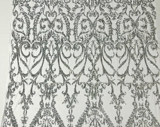 Silver shiny sequin damask design on a white 4 way stretch mesh-sold by the yard.
